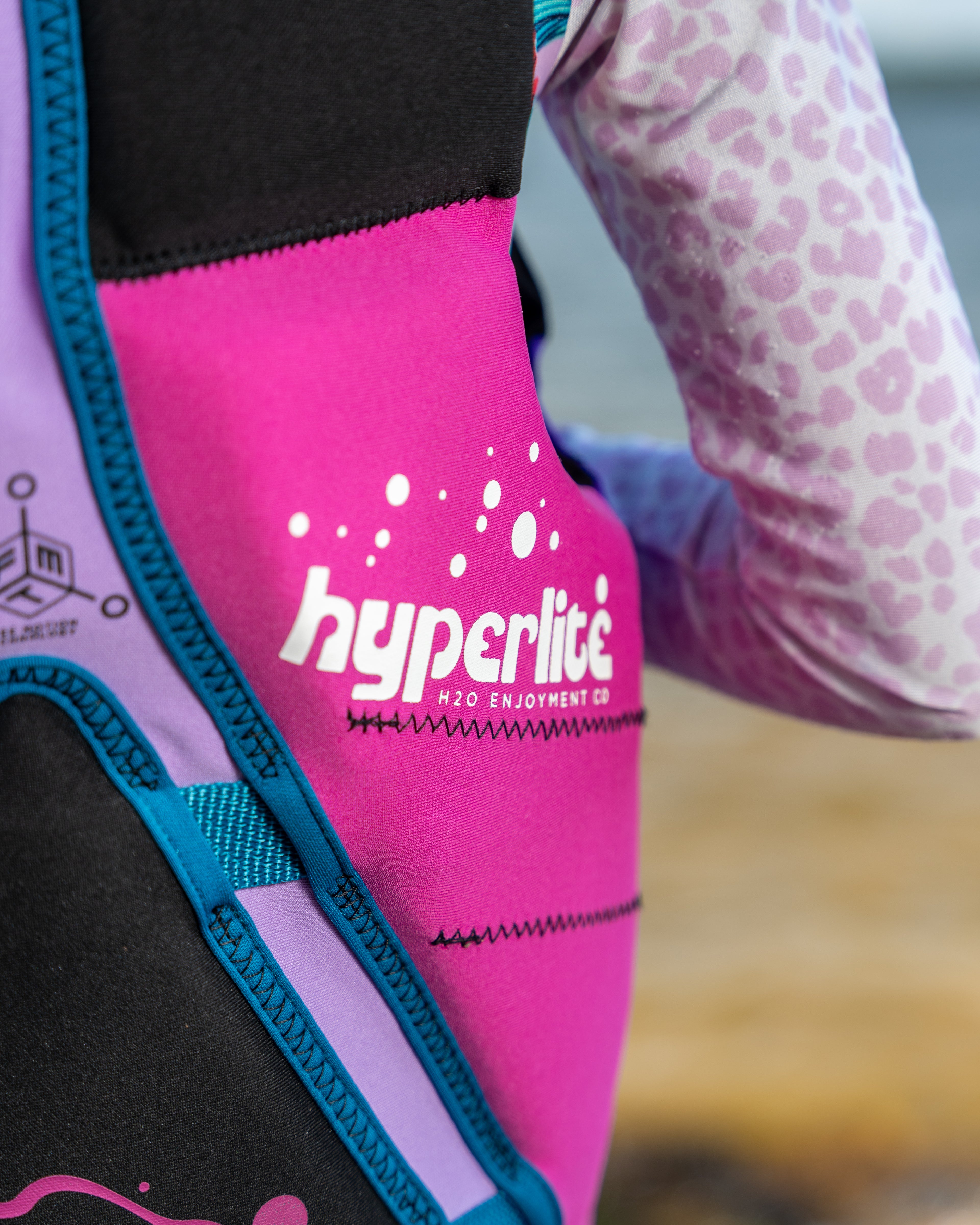 Close-up of a pink life jacket with 'Hyperlite' branding.