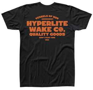 Back view of black t-shirt with large orange logo that says Vessels of H20 amusement, HYPERLITE WAKE CO. , Quality goods don't fear time, USA.