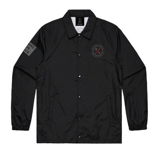 Front view of the black Riders Coach Jacket with chest patch and sleeve graphic.