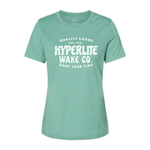 Front view of green womens t-shirt with a large white logo that states Quality Goods, EST 1991, Hyperlite Wake CO., Don't fear time on the center of the chest.