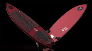 Angled view of red Accelerator wakesurf board with black traction pads and fins.