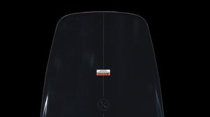 Detail view of the Pleasure wakeboard tail with logo circle and warning label.