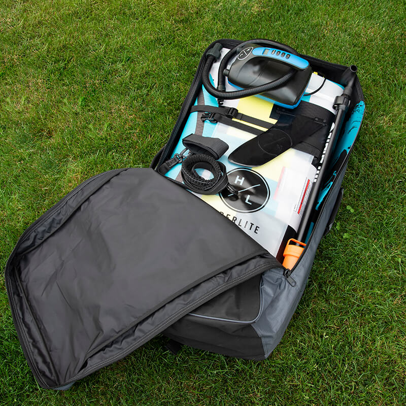 Open backpack on grass, containing camping equipment and a telescope.