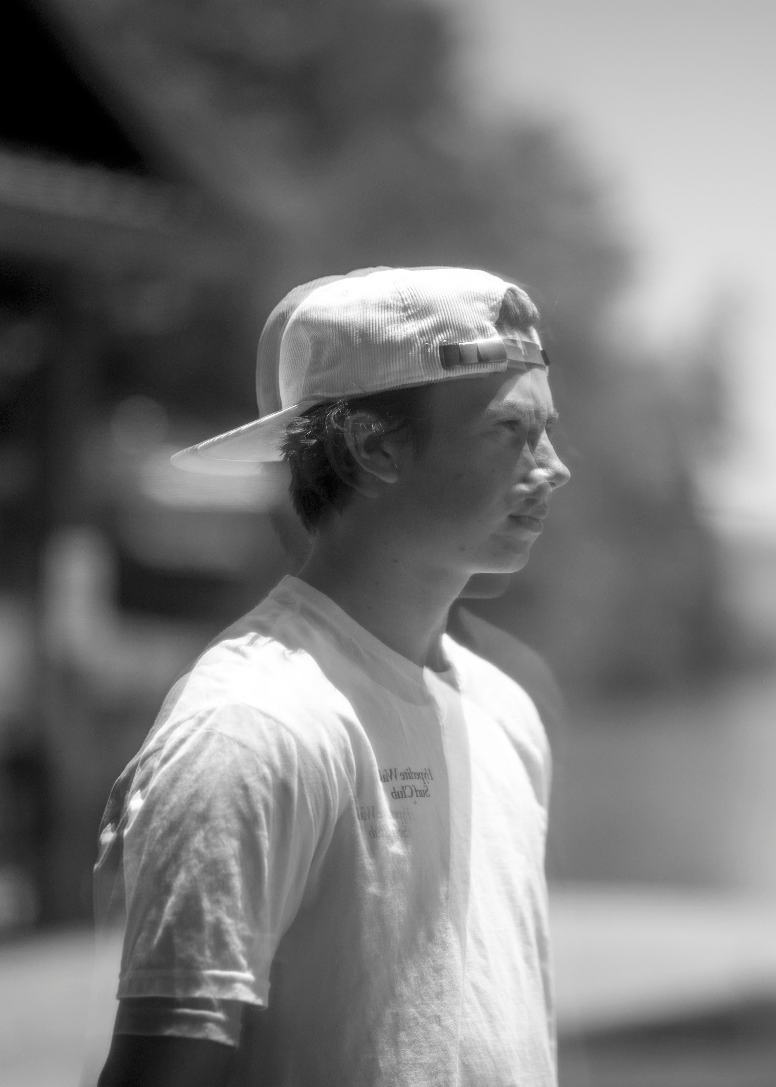 Black and white photo of a young person in a cap looking away.