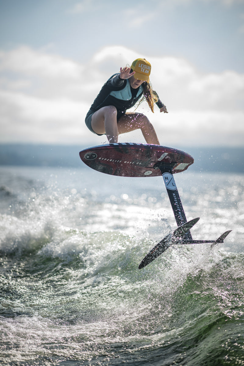 Person hoverboarding on ocean with yellow helmet and Majik Karpet w/MK Carbon Foil Kit.