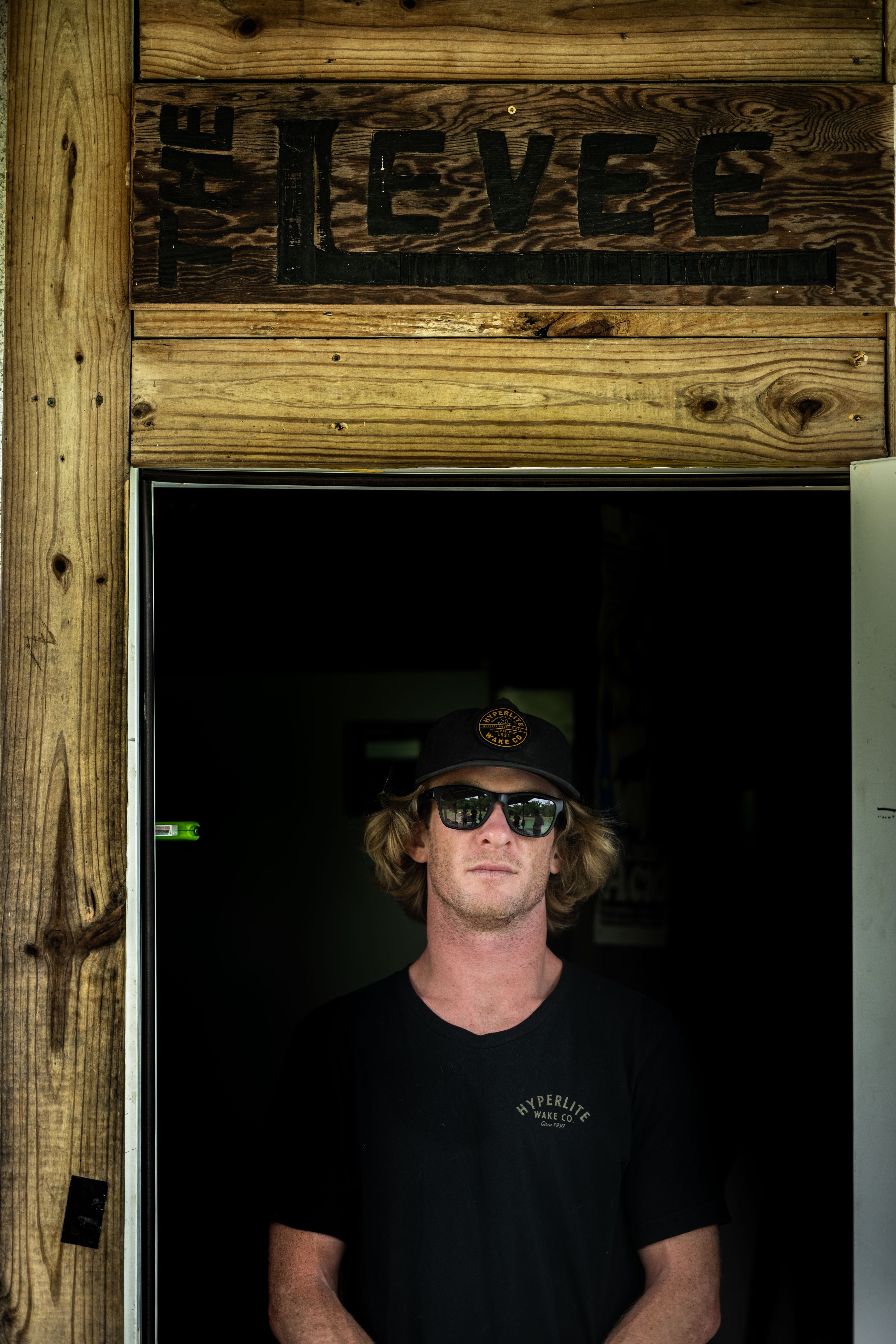 Person in sunglasses standing under The Levee sign, partially in doorway.