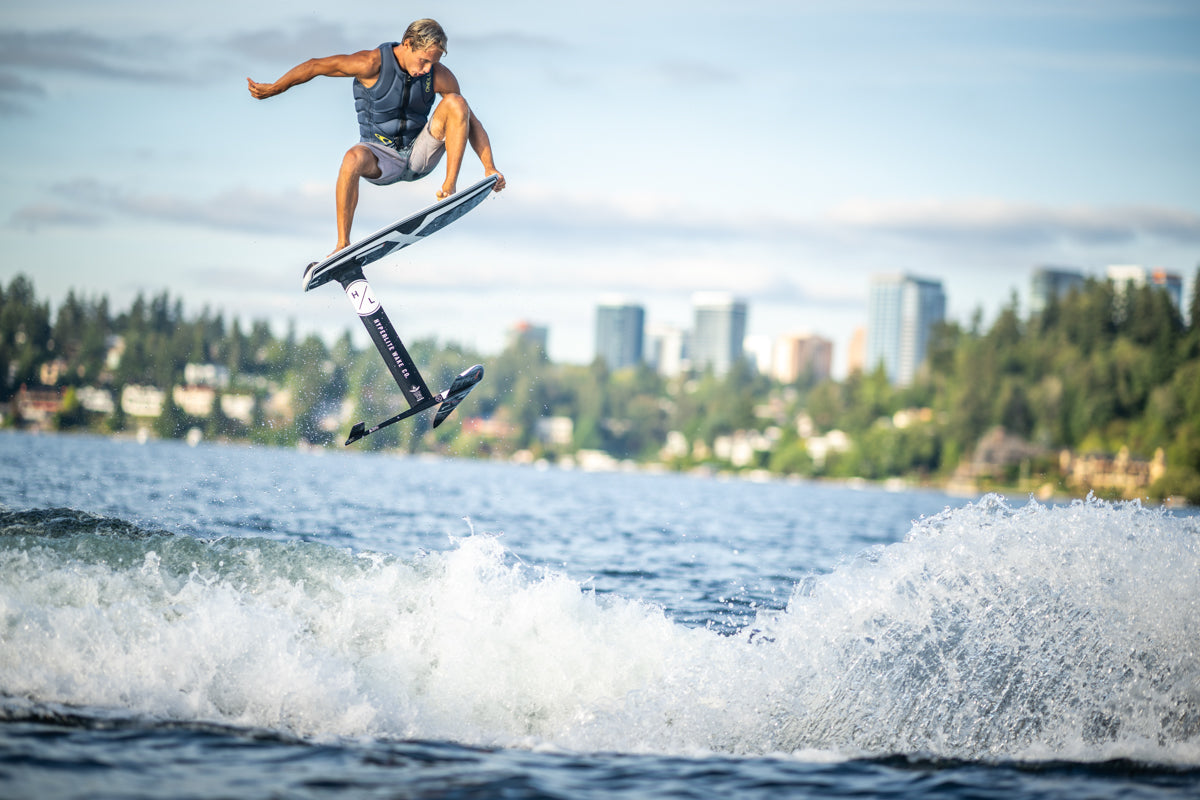 Person surfing on a Starship w/MK Foil Kit with city skyline, featuring Durashell Construction.