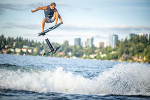 Person surfing on a Starship w/MK Foil Kit with city skyline, featuring Durashell Construction.