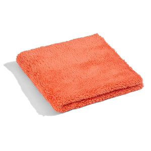 Orange microfiber cleaning towel neatly folded.