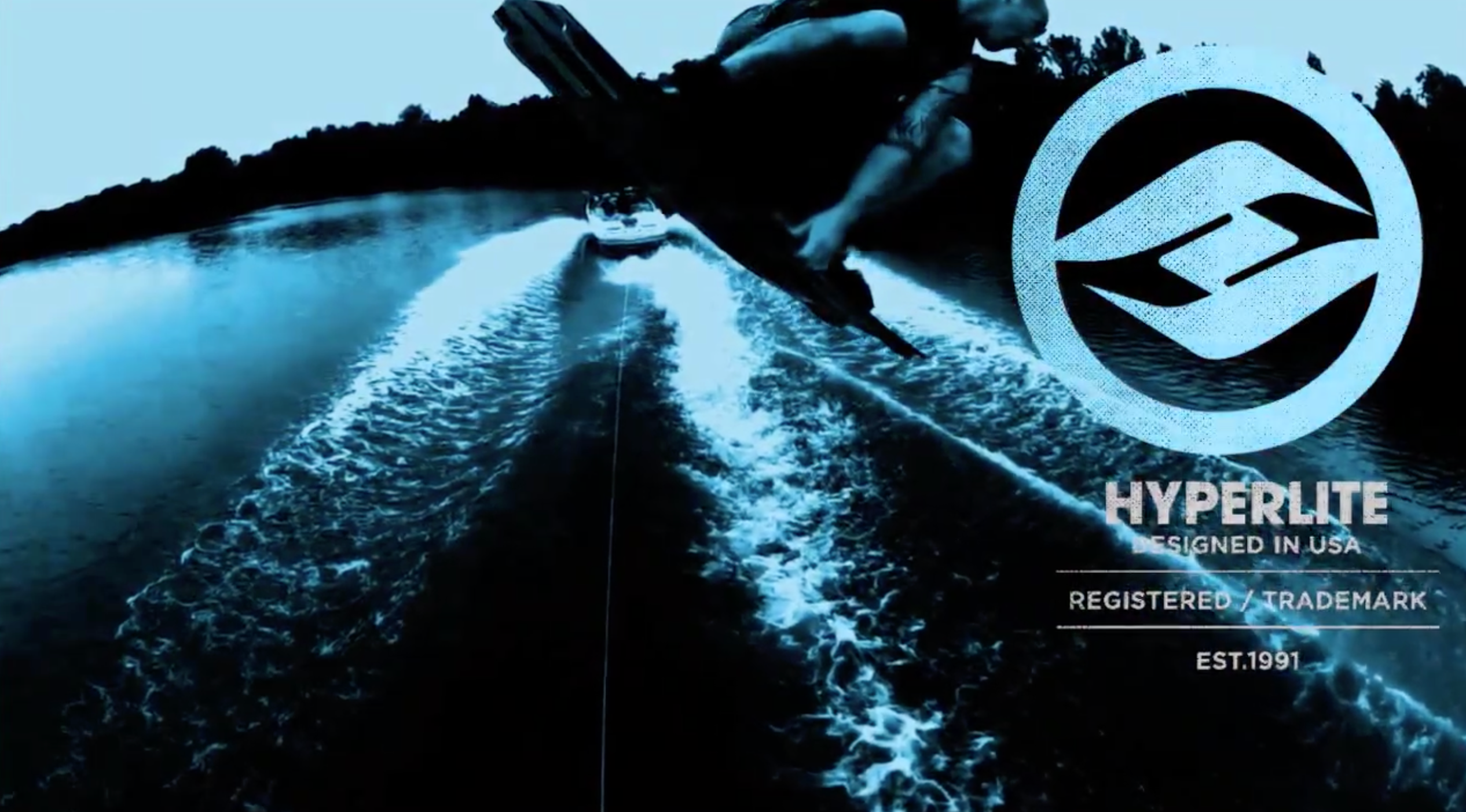 Person wakeboarding mid-air behind a boat, logo reads Hyperlite, Est.1991.