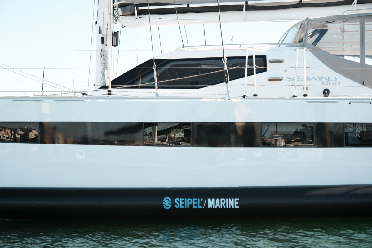 Side view of a boat hull with Seipel Marine inflatable dock fender mounted along the waterline.