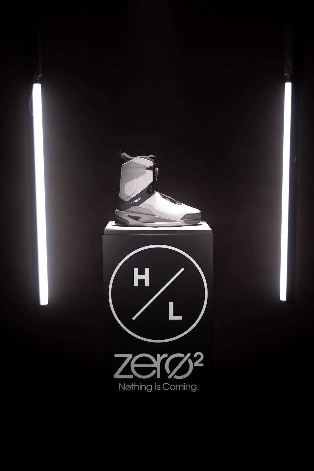 A futuristic sneaker displayed on a pedestal with H/L logo and Nothing is Coming text.